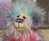 Pru has beautiful, hand painted eyes with eyelids, a splendid nose embroidered with individual threads to compliment her colouring and she has a sweet, friendly smile. Pru's face is a very long and wispy cream mohair with subtle lilac tipping, the fronts of her ears are a sparse, twirly mohair hand dyed blue and on top of her head she has a mop of very dense and soft sky blue faux fur