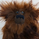 Bruno Pinehandle is a wild thing, yet a very friendly wild thing, a one of a kind, artist bear by Barbara-Ann Bears in wonderful shaggy brown mohair, he stands 12 inches/30 cm tall. He is made from a long dark brown mohair, with a longer dark brown mohair with black tipping and he has dark brown wool felt paw pads. He has beautiful hand painted glass eyes with hand coloured eyelids, a splendid nose embroidered in black cotton and a broad and cheerful smile