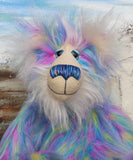 Celeste a huggable and colourful one of a kind artist bear in stunning faux fur and gorgeous fluffy mohair by Barbara-Ann Bears, she stands 18 inches/46 cm tall. Se is made from a long faux fur in blue, pink and yellow with, long fluffy white mohair, large hand painted eyes with eyelids, a splendid nose and a huge, beaming smile.