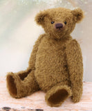 brownish-green teddy bear sitting on a wooden surface with a soft, blurred background