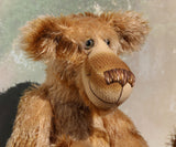 Fingal is quite a large and comical, one of a kind, artist bear by Barbara-Ann Bears in wonderful batik German mohair, he stands 20.5 inches/ 52cm tall and is 15 inches/38 cm sitting. Fingal is made from batik mohair in bands and patches of coffee and beige with greyish beige German wool felt paw pads, beautiful hand painted glass eyes with hand coloured eyelids, an impressive and wonderfully embroidered nose and an engaging smile.