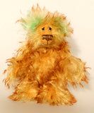Green Eared Banana Stalker is a little, endearingly sweet and joyful, one of a kind, artist bear by Barbara-Ann Bears in wonderfully fluffy mohair, he stands 6.5 inches/17 cm tall. He is mostly made from a long golden mohair with brown tipping, with hand dyed green mohair ears, and beige wool felt paw pads. He has hand painted glass eyes with hand coloured eyelids, a wonderfully embroidered nose and a broad and cheerful smile.