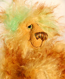 Green Eared Banana Stalker is a little, endearingly sweet and joyful, one of a kind, artist bear by Barbara-Ann Bears in wonderfully fluffy mohair, he stands 6.5 inches/17 cm tall. He is mostly made from a long golden mohair with brown tipping, with hand dyed green mohair ears, and beige wool felt paw pads. He has hand painted glass eyes with hand coloured eyelids, a wonderfully embroidered nose and a broad and cheerful smile.