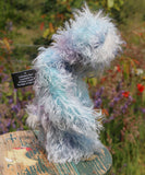 Hyssop is a gentle, happy teddy bear, a beautifully blue one of a kind, hand dyed mohair artist bear by Barbara-Ann Bears, he stands 9 inches/23 cm tall  Hyssop is mainly made from a fairly long, sparse hand dyed sky blue, coupled with a long fluffy white mohair with blue tipping and hand-dyed velvet paw pads.   Hyssop has beautiful hand painted eyes with eyelids, a nose embroidered from individual threads to complement his colouring and he has a huge, friendly smile.