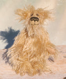 Plush bear with a fluffy texture standing on a wooden surface.