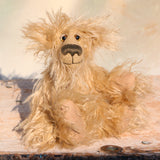 Plush teddy bear sitting on a wooden surface with a blurred background