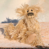 Plush teddy bear sitting on a wooden surface with a neutral background