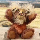 Nimble Nigel sitting and waving with both arms. Nimble Nigel is an endearingly sweet and joyful one of a kind artist bear by Barbara-Ann Bears in wonderful brown mohair, he stands just 6.5 inches/17cm