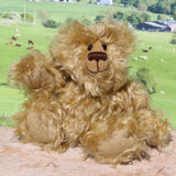 Robbie McFluff is a cute and quite little one of a kind artist bear in wildly curly mohair by Barbara-Ann Bears, he stands just 7 inches(18 cm) tall and is 5.5 inches (14 cm) sitting. Robbie is made from wonderful, wildly curly beige gold mohair, with a slightly warmer backcloth and he has beige German wool felt paw pads