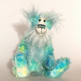 Sebastian Swoon is an elegant and beautifully coloured one of a kind, hand dyed mohair artist bear by Barbara-Ann Bears, he stands 14 inches/36 cm tall and is 10.5 inches/26 cm sitting.He is made from mohair hand dyed in shades of blue, green, turquoise and lime, His face, the fronts of his ears and the underside of his tail are made from a long, fluffy white faux fur and he has hand dyed velvet paws
