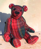 Red plaid teddy bear on a wooden surface