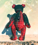 Back view of a plaid teddy bear on a wooden surface with a blurred background