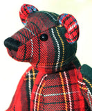 Red plaid-patterned teddy bear on a blurred background