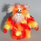 Sunny is a flamboyant, fun-loving and comical, one of a kind, artist bear by Barbara-Ann Bears in luxurious mohair and beautifully colourful faux fur and he stands 11.5 inches/29 cm tall and is 9 inches/23cm sitting.  Sunny is made from a beautiful faux fur in bright yellow, orange and red, his face the fronts of his ears and the underside of his tail are a long white fluffy mohair and he has bright gold wool felt paw pads