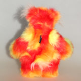 Sunny is a flamboyant, fun-loving and comical, one of a kind, artist bear by Barbara-Ann Bears in luxurious mohair and beautifully colourful faux fur and he stands 11.5 inches/29 cm tall and is 9 inches/23cm sitting.  Sunny is made from a beautiful faux fur in bright yellow, orange and red, his face the fronts of his ears and the underside of his tail are a long white fluffy mohair and he has bright gold wool felt paw pads