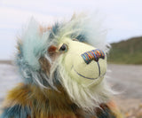 Close up of a colourful teddy bear with a textured fur pattern against a blurred natural background
