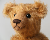 Ambrose is a charming, traditional one of a kind artist bear in German mohair by Barbara Ann Bears, he stands 10 inches/27 cm tall and is 7.5 inches/22 cm sitting. Ambrose is made from beautiful, slightly wavy, warm antique gold German mohair with fawn ultrasuede paw pads and vintage boot buttons for eyes