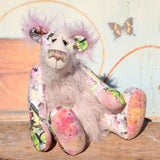 Amelie Papillion is an extremely beautiful, one of a kind artist bear by Barbara-Ann Bears, she stands 17.5 inches (44 cm) tall and is 12 inches (30 cm) sitting. Amelie Papillion is made from the most wonderful printed fabric, with areas of white, grey and pink and on top of this a myriad of fluttering butterflies