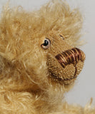 Amos has small hand painted glass eyes with eyelids, he has a pert little nose embroidered from several shades of beige and brown perle cotton and a beaming smile