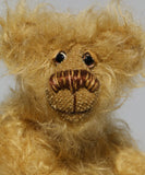 Amos has small hand painted glass eyes with eyelids, he has a pert little nose embroidered from several shades of beige and brown perle cotton and a beaming smile