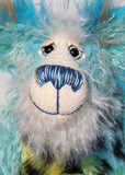 Billy Calypso has beautiful hand painted eyes with eyelids, a nose embroidered from individual threads to complement his colouring and he has a huge, friendly smile. Billy's face is a long and fluffy white mohair with blue tipping. On top of Billy's head and on the backs of his ears is a very long aqua faux fur with tufts of warm beige.
