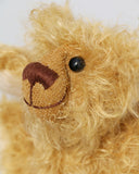 Bobbin has black boot button eyes, like the old teddy bears. He has a carefully embroidered nose and a warm beaming smile which gives him that puppy dog 'please pick me up and love me' expression