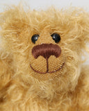 Bobbin has black boot button eyes, like the old teddy bears. He has a carefully embroidered nose and a warm beaming smile which gives him that puppy dog 'please pick me up and love me' expression