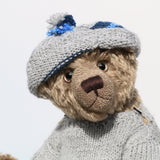 Bosworth is a solid and distinguished one of a kind, traditional, mohair artist teddy bear by Barbara Ann Bears, he stands 17 inches (43cm) tall and is 12 inches (31cm) sitting and made from fairly long, slightly wavy greyish-brown brown mohair with a hint of green, he has beige wool felt paw pads and hand painted eyes and wears a hand knitted jumper and hat