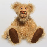 Brodie is a very sweet and friendly artist bear in wildly curly mohair by Barbara-Ann Bears, he stands 8.5 inches/21 tall and is 6 inches 15 cm sitting.  Brodie is made from curly beige gold mohair with brown wool felt paws, he has hand painted glass eyes with eyelids, a carefully embroidered nose and a beaming smile