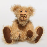 Brodie is a very sweet and friendly artist bear in wildly curly mohair by Barbara-Ann Bears, he stands 8.5 inches/21 tall and is 6 inches 15 cm sitting.  Brodie is made from curly beige gold mohair with brown wool felt paws, he has hand painted glass eyes with eyelids, a carefully embroidered nose and a beaming smile