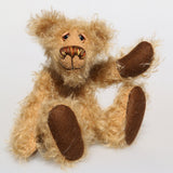 Brodie is a very sweet and friendly artist bear in wildly curly mohair by Barbara-Ann Bears, he stands 8.5 inches/21 tall and is 6 inches 15 cm sitting.  Brodie is made from curly beige gold mohair with brown wool felt paws, he has hand painted glass eyes with eyelids, a carefully embroidered nose and a beaming smile