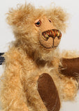 Brodie is a very sweet and friendly artist bear in wildly curly mohair by Barbara-Ann Bears, he stands 8.5 inches/21 tall and is 6 inches 15 cm sitting.  Brodie is made from curly beige gold mohair with brown wool felt paws, he has hand painted glass eyes with eyelids, a carefully embroidered nose and a beaming smile