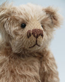 Buster is a very sweet and friendly, quite traditional, one of a kind, mohair artist teddy bear by Barbara Ann Bears, he stands 10 inches/25 cm tall and is 7.5 inches/19 cm sitting. Buster is made from beautiful, quite sparse, fairly straight, soft beige mohair, with German wool-felt paw pads and spherical, glass eyes