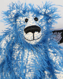 Charlie McCubbin is made from a sparse, stringy blue mohair that has a pale, almost white, cotton backcloth, giving him a charmingly fluffy, scruffy appearance. Charlie's paw pads are made from the same mohair, trimmed down to the finest stubble.  Charlie McCubbin has small spherical glass eyes, that catch the light whichever way you look at him, he has a pert little nose embroidered from fine black perle cotton and a beaming smile