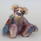 Clarence Sunbeam is a loveable and subtly coloured, one of a kind artist bear, in muted hand dyed mohair by Barbara-Ann Bears, he stands 8 inches/20 cm tall. Clarence Sunbeam is mostly made from a fairly short and sparse mohair hand dyed in indigo, lilac, mauve, rose and ultramarine with splashes of rusty amber.  His face is a very long, feathery pale beige mohair and the backs of his ears and the underside of his tail are a similarly coloured shorter, twirly mohair