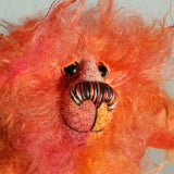 Flamin' Frizz has hand painted glass eyes with hand coloured eyelids. He has a carefully embroidered nose, sewn from individual threads to match the colouring of his mohair, and a warm beaming smile which gives him that puppy dog 'please pick me up and love me' expression