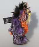 Geoffrey Sniggers is a little exceedingly happy one of a kind, mohair artist bear by Barbara-Ann Bears, he stands just 6 inches/15cm tall and is 5 inches/13 cm sitting. He's made from a black tipped violet mohair, mixed with orange and yellow hand dyed mohair and black faux fur on his head with long plumes of colour