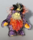 Geoffrey Sniggers is a little exceedingly happy one of a kind, mohair artist bear by Barbara-Ann Bears, he stands just 6 inches/15cm tall and is 5 inches/13 cm sitting. He's made from a black tipped violet mohair, mixed with orange and yellow hand dyed mohair and black faux fur on his head with long plumes of colour