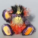 Geoffrey Sniggers is a little exceedingly happy one of a kind, mohair artist bear by Barbara-Ann Bears, he stands just 6 inches/15cm tall and is 5 inches/13 cm sitting. He's made from a black tipped violet mohair, mixed with orange and yellow hand dyed mohair and black faux fur on his head with long plumes of colour