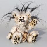 Great Scott is a little, endearingly sweet one of a kind, artist bear by Barbara-Ann Bears in fluffy mohair and wonderful faux fur. He stands just 6 inches/15 cm tall and is 5 inches/18 cm sitting. He is made from dense spotty faux fur with long black plumes of faux fur around his head and a little spotty pink tail.