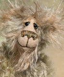 Herbie Hedgerow is a gentle, beautifully coloured one of a kind mohair artist bear by Barbara-Ann Bears, he stands 10 inches/25 cm tall and is 8 inches/20 cm sitting. Herbie Hedgerow is mainly made from a long, fluffy, distressed pale greyish-green mohair coupled with long and fluffy pale grey mohair and hand-dyed velvet paw pads. Herbie has hand painted eyes with eyelids, a carefully embroidered nose and he a sweet, friendly smile