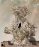 Herbie Hedge is a gentle, beautifully coloured one of a kind mohair artist bear by Barbara-Ann Bears, he stands 10 inches/25 cm tall and is 8 inches/20 cm sitting. Herbie Hedgerow is mainly made from a long, fluffy, distressed pale greyish-green mohair coupled with long, fluffy pale grey mohair and hand-dyed velvet paw pads. Herbie has hand painted eyes with eyelids, a carefully embroidered nose and he a sweet, friendly smile