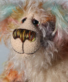 Herbie has beautiful hand painted glass eyes with eyelids, a pert nose embroidered with individual threads to match his mohair and an appealing smile. His face is a long tousled cream mohair and the fronts of his ears  and the underside of his tail are made from a longish distressed mohair hand dyed in blue with a little splash of pink