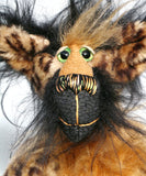 Houdini has large, beautiful, glass eyes which have been painted in gentle shades of green (like a cat's eyes) and these have hand coloured eyelids. He has an impressive nose embroidered from individual threads to match his colours and a quizzical smile. He is stuffed with plastic pellets and polyester stuffing to make him a little heavier and more cuddly