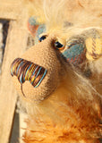 Howard Huckleford is made from a beautifully coloured Harris Tweed and a long, fluffy brown tipped blonde mohair with beige German wool felt paw pads  Howard Huckleford has large, beautiful, hand painted glass eyes (painted to match his colours) with hand coloured eyelids, an impressive nose embroidered from individual threads to match his colouring and a beaming smile
