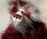 Molly Cuddle is mostly made from a long, silky faux fur which is mainly burgundy in colour but with some very subtle black tipping. Her face, the fronts of her ears and the underside of her tail are an even longer, fluffy white mohair. Molly's burgundy ultrasuede paw pads match her colours perfectly.  Molly Cuddle has beautiful, hand painted eyes with eyelids, a splendid nose embroidered from individual threads to complement her colouring and she has a sweet, friendly smile