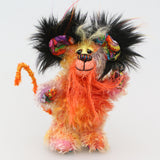 Mousetopheles is made from a short mohair dyed in oranges, yellows and violet and his tummy is a longer mohair dyed gold and orange. The sides of his face are made from a very long mohair dyed orange and the top of his face is a long mohair dyed yellow. The fronts of his ears and his paw pads are a gruesome fabric, the top of his head is a long black faux fur with sprouts of yellow, orange, magenta and purple. Mousetopheles has a long orange pipe-cleaner tail which is wrapped with lilac cotton thread