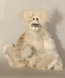 Nooki is made from the most gorgeous and luxurious fur, mainly a soft and fluffy, very dense, straight pile, animal print (Lynx) faux fur which is white with a very pale beige pattern, while his face, the fronts of his ears and the underside of his tail are made from even longer, feathery, creamy white mohair. Nooki has pale beige German wool felt paw pads that compliment his mohair perfectly.