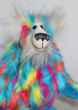 Pedro Piccolo is mostly made from a fairly long and fluffy multi-coloured faux fur in sky blue with flashes of yellow, magenta, orange and mauve. His face, the fronts of his ears and the underside of his tail are a very long and fluffy white mohair. Pedro Piccolo has blue velvet paw pads which complement his colouring perfectly. He has beautiful, hand painted glass eyes with eyelids, a wonderful nose embroidered from individual threads to match his colouring and a charming smile