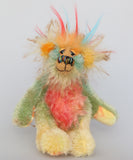 Salsa Verde is a very happy and colourful little one of a kind, hand dyed mohair and faux fur artist bear by Barbara-Ann Bears, he stands 6.5 inches/16 cm tall. Salsa Verde is made from hand dyed mohair, with long plumes of faux fur on his head, hand painted eyes, a multicoloured nose and a beaming smile, a happy bear!
